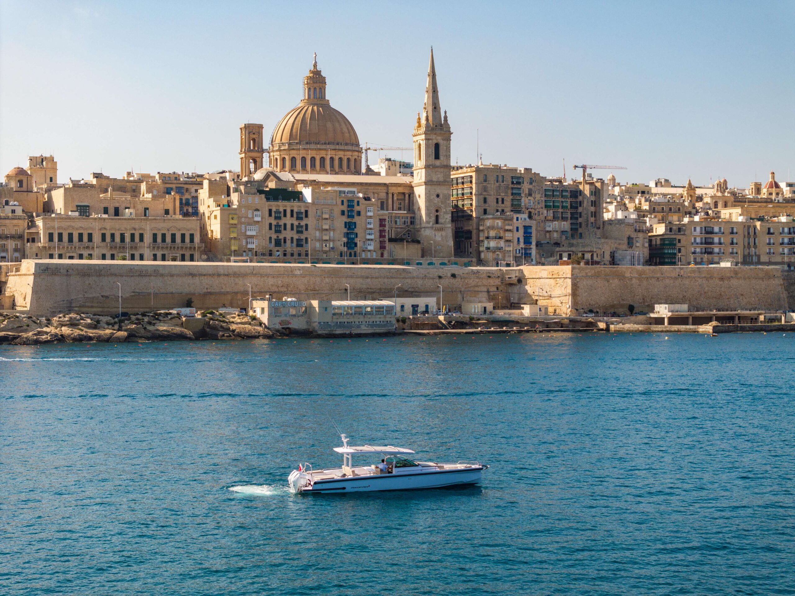 Sport yacht running off the Maltese coast at golden hour