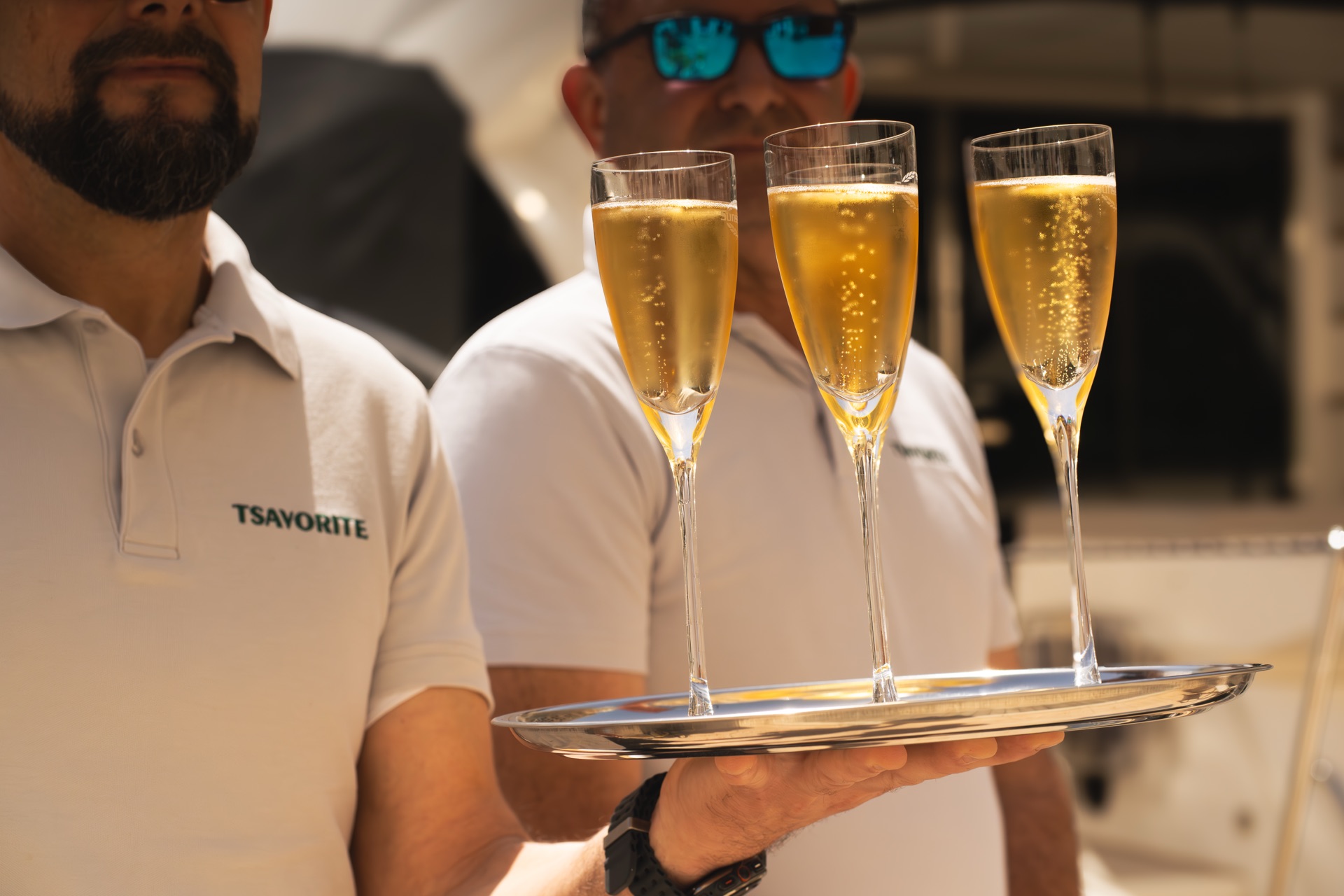 Crew with champagne on the aft deck of a Malta charter yacht